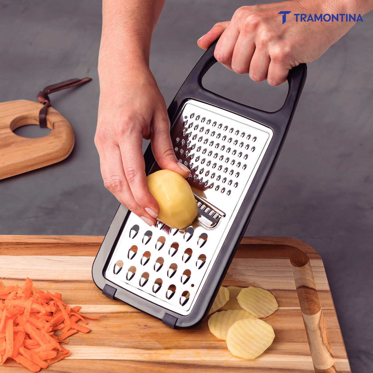 Utilitá stainless steel grater with black polypropylene handle and non-slip rubber base by Tramontina India.