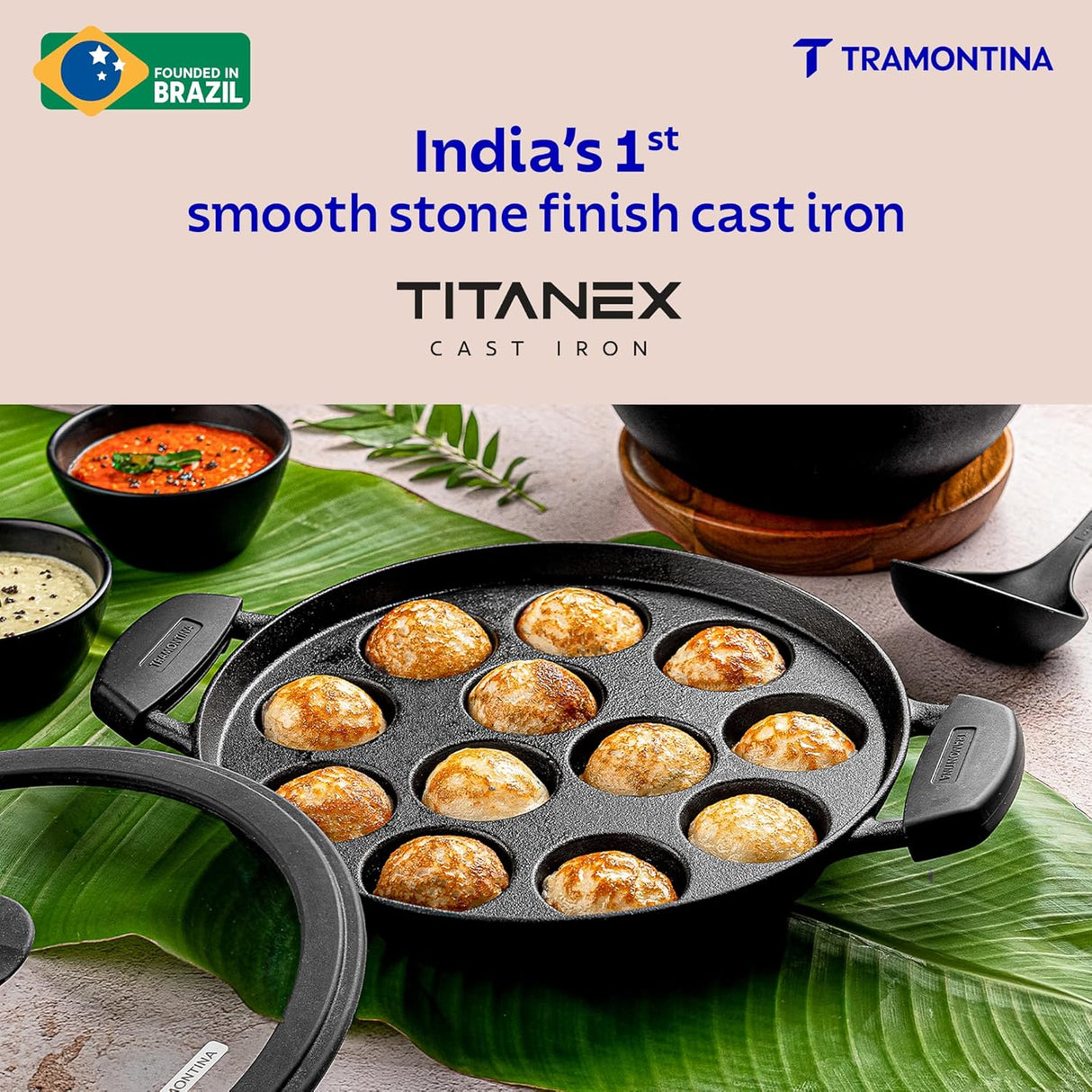Tramontina India 26cm pre-seasoned cast iron paniyaram pan with 12 pits, showcasing its sturdy design and cooking surface.