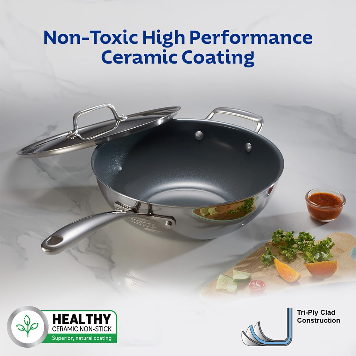 Tramontina India Fusao EX+ 26cm triply ceramic wok with stainless steel lid on a stovetop, showcasing its sleek design and durable surface.