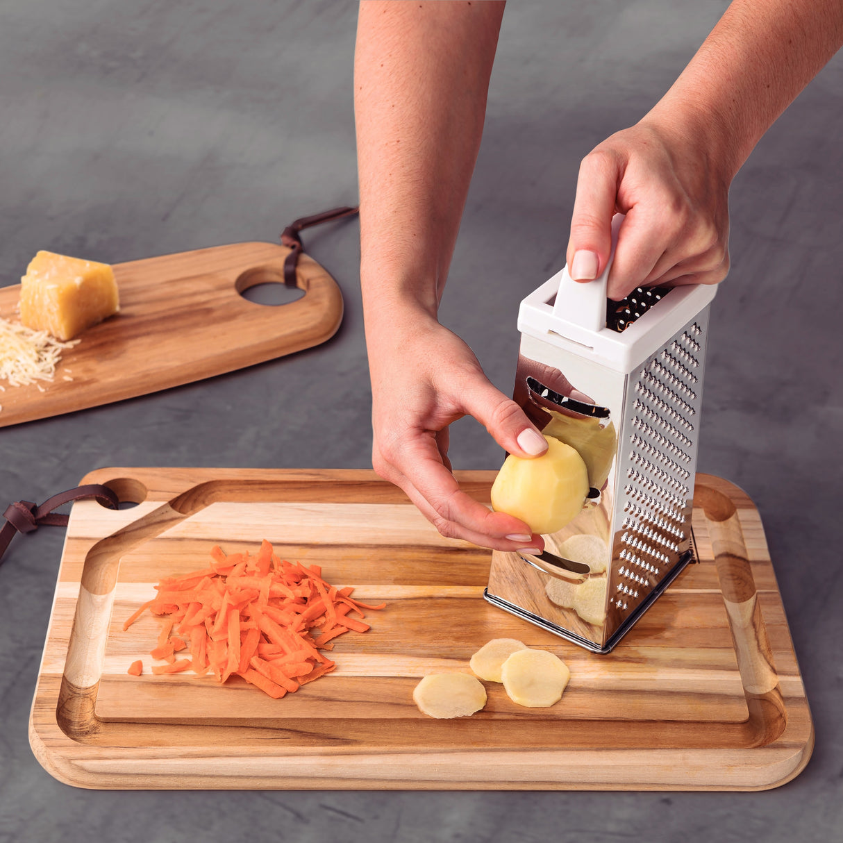 Stainless steel Tramontina India Utilitá 4-sided grater with white ABS handle, showing multiple grating surfaces and a sturdy design.