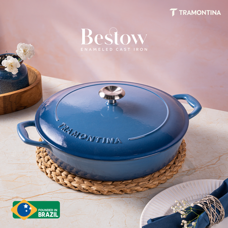Tramontina India Bestow enameled cast iron round braiser in medium blue, 3.8L, showing a close-up of the durable cooking surface