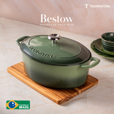 Tramontina India Bestow enameled cast iron oval Dutch oven in cactus green, 6.6L, shown in a kitchen setting with lid on.
