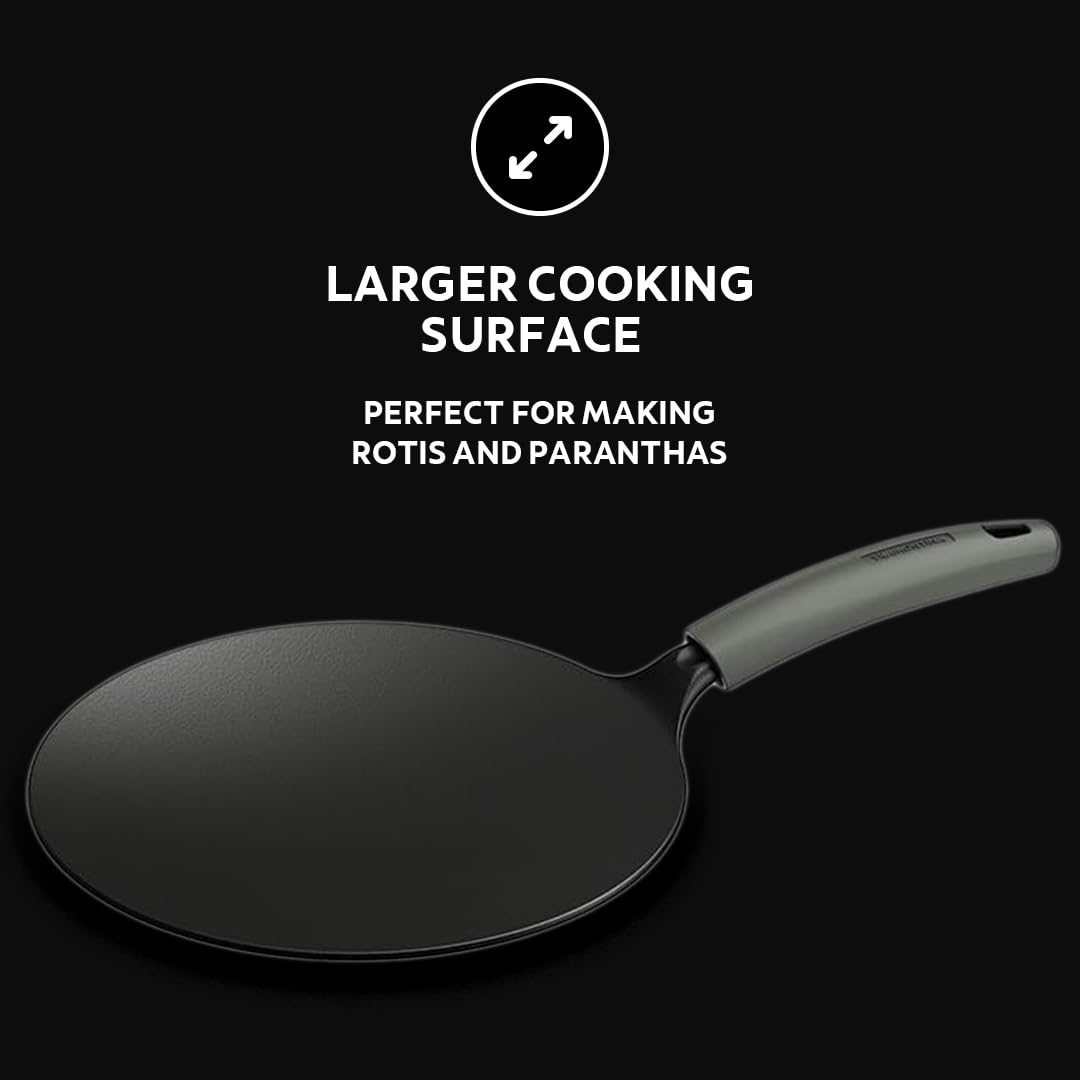Tramontina India 26cm pre-seasoned cast iron concave tawa with heat resistant silicone grip on a wooden surface.