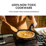 Tramontina India 26cm pre-seasoned cast iron concave roti tawa with heat-resistant silicone grip on a kitchen countertop.