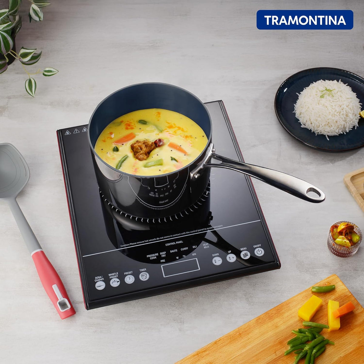 Stainless steel Tramontina India Fusao EX+ 16cm ceramic tri-ply sauce pan with lid, 2.1L capacity, on stovetop.