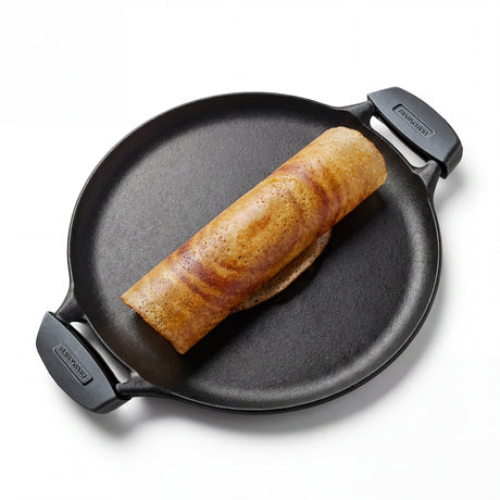 Tramontina India Titanex 30cm pre-seasoned cast iron dosa tawa with dual handles and heat-resistant silicone grips.