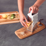 Stainless steel Tramontina India Utilitá 4-sided grater with white ABS handle for versatile food prep and grating tasks.