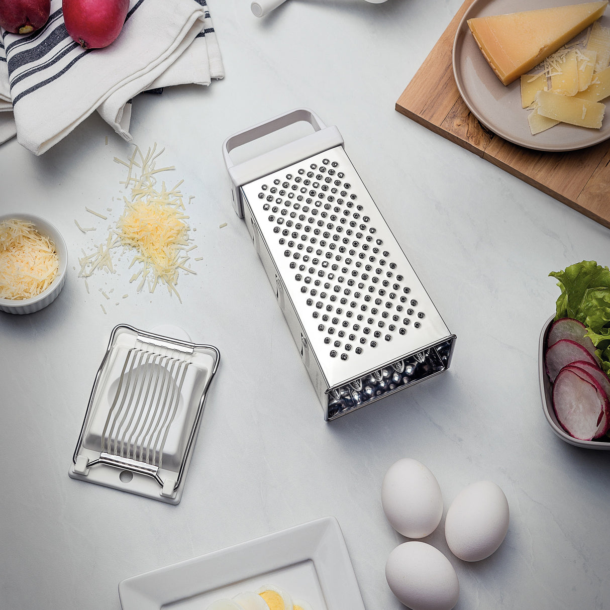 Stainless steel Utilitá 4-sided grater with white ABS handle by Tramontina India, ideal for shredding and grating in the kitchen.