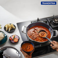 Tramontina India Fusao EX+ 30cm ceramic stainless steel tri-ply Kadai with lid, 5.7L capacity, shown on a kitchen countertop.