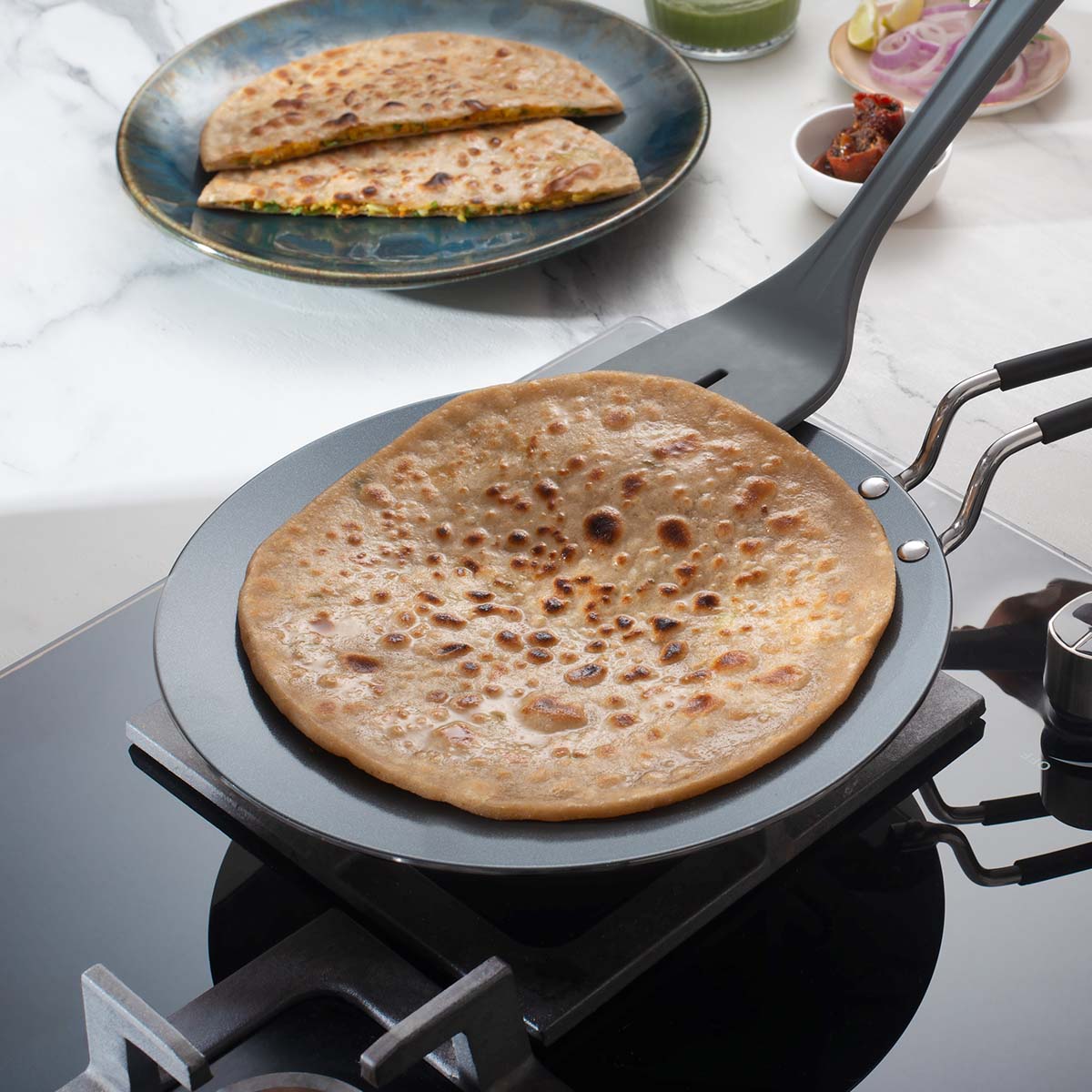 Tramontina India Fusao EX+ 26cm ceramic stainless steel tri-ply concave Tawa with 4mm thickness for versatile cooking.